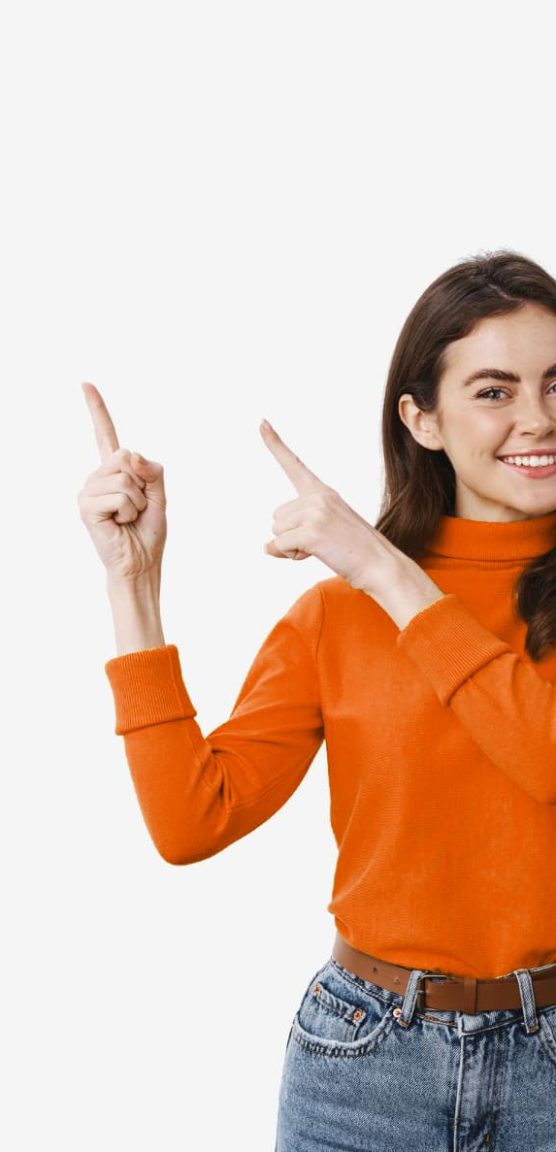 Grinsende Frau in orangenem Pullover zeigt in die Luft Version 3