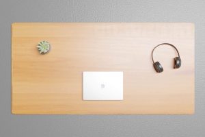 Holz Schreibtischplatte mit Laptop und Kopfhörern auf grauem Boden mit Sukkulente